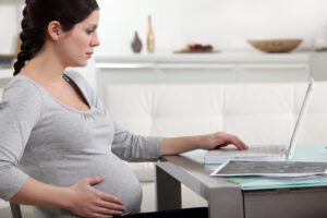 Pregnant woman reading news about infertility clinics on the Internet | Tennessee Reproductive Medicine | Chattanooga, TN