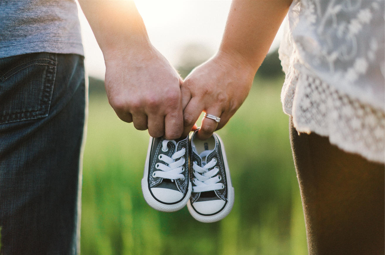 fertility testing | Tennessee Reproductive Medicine | mother, father and baby shoes in field 