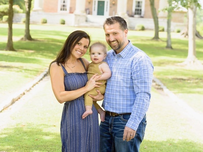 Mom, dad and baby smile in the park after varicocele issue | Tennessee Reproductive Medicine | Chattanooga, TN