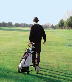 Man Walking a Golf Course with His Clubs | Tennessee Reproductive Medicine