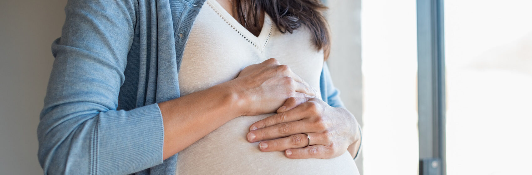 Pregnant woman in blue sweater after successful infertility treatment | Tennessee Reproductive Medicine | Chattanooga, TN